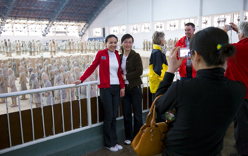 Tourists pose by Pit 1 at Qin Museum, exhibition halls of Terracotta Warriors, China