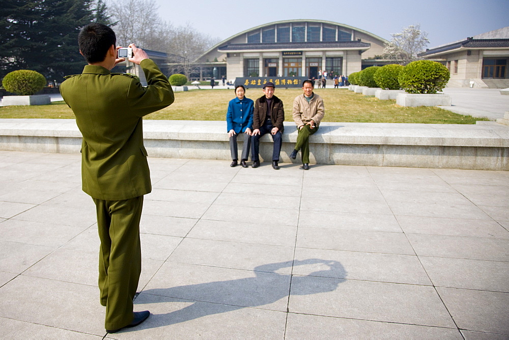 Tourists pose for a photograph outside Qin Museum, exhibition halls of Terracotta Warriors, Xian, China