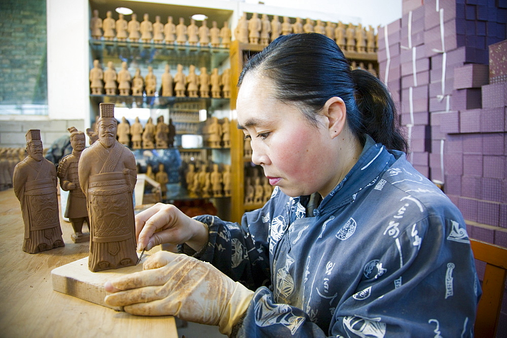 Woman makes Terracotta Warrior souvenirs in factory, Xian, China