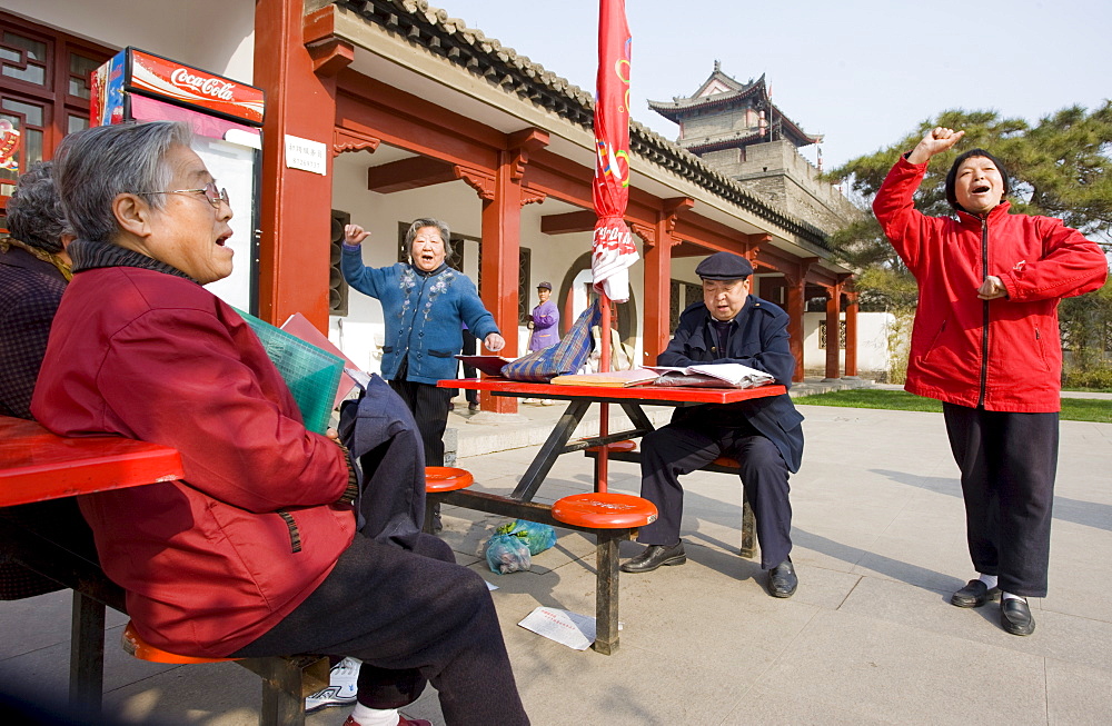 People gather to sing, part of their morning exercise in the park by the City Wall, Xian, China