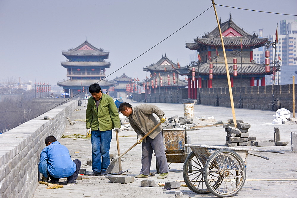 Workmen carry out repair work on The City Wall, Xian, China