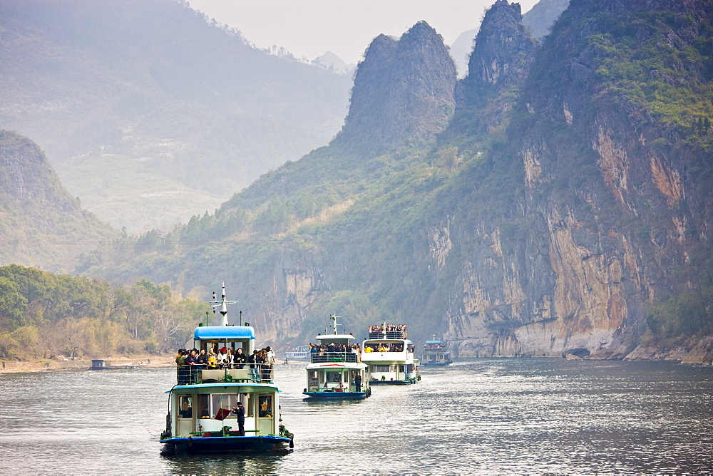 Tourist boats travel along Li River between Guilin and Yangshuo, China