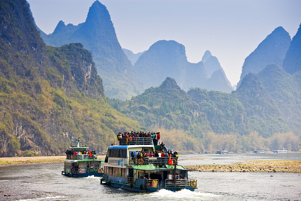 Tourist boats travel along Li River between Guilin and Yangshuo, China