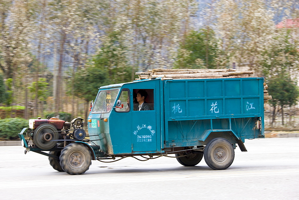 Delivery tractor truck containing pile of wood in Guilin, China. China's construction industry is thriving.