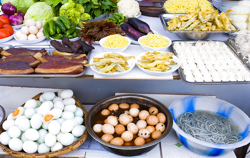 Duck breasts, battered fish and preserved '1000 year old' eggs, at food stall in Fengdu, China