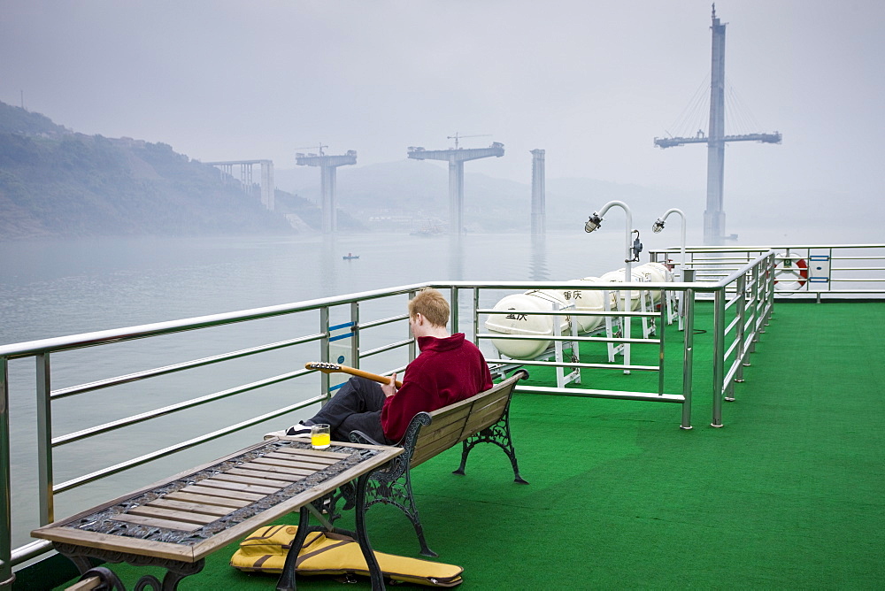 Tourist plays guitar on deck of Victoria Line Cruise Ship, Yangtze River, China