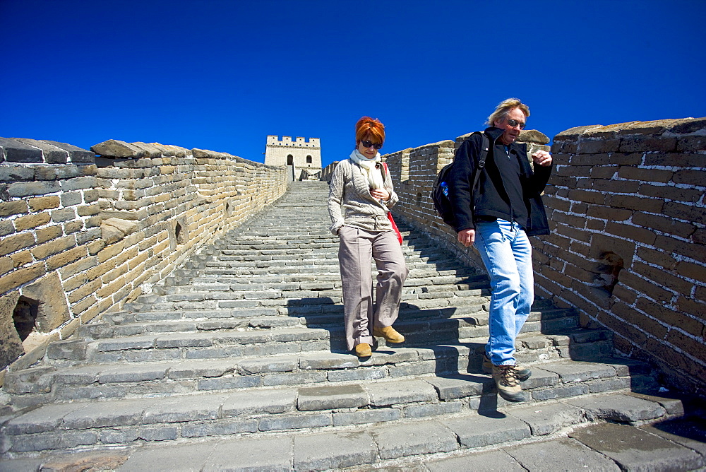 Western tourists walk the ancient Great Wall of China at Mutianyu, north of Beijing, China