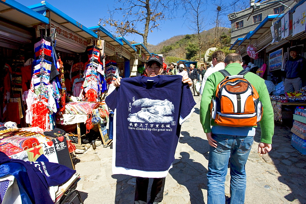 Tourists walk past souvenir tee shirt stating I have climbed up the The Great Wall, in Mutianyu, north of Beijing