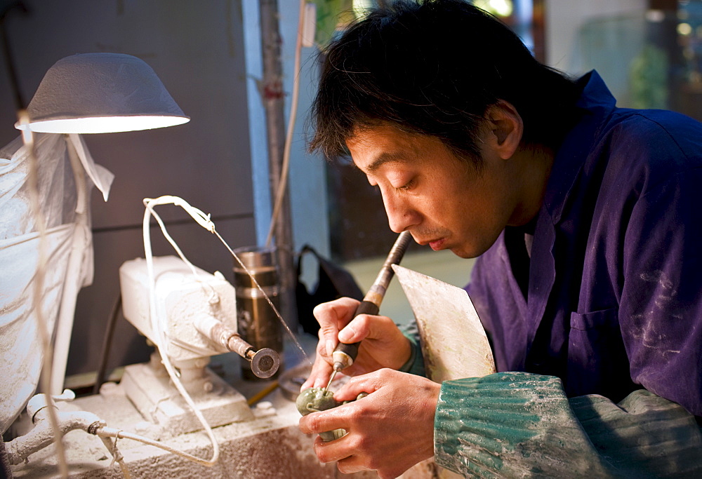 Jade craftsman at work in the Beijing Dragon Land factory in Beijing, China