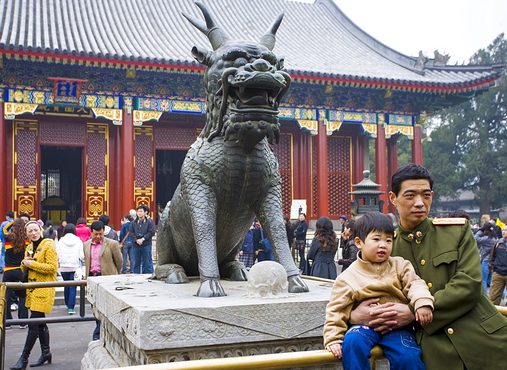 Father and son by Qilin statue, Summer Palace, Beijing. China has a one child family policy to limit population.