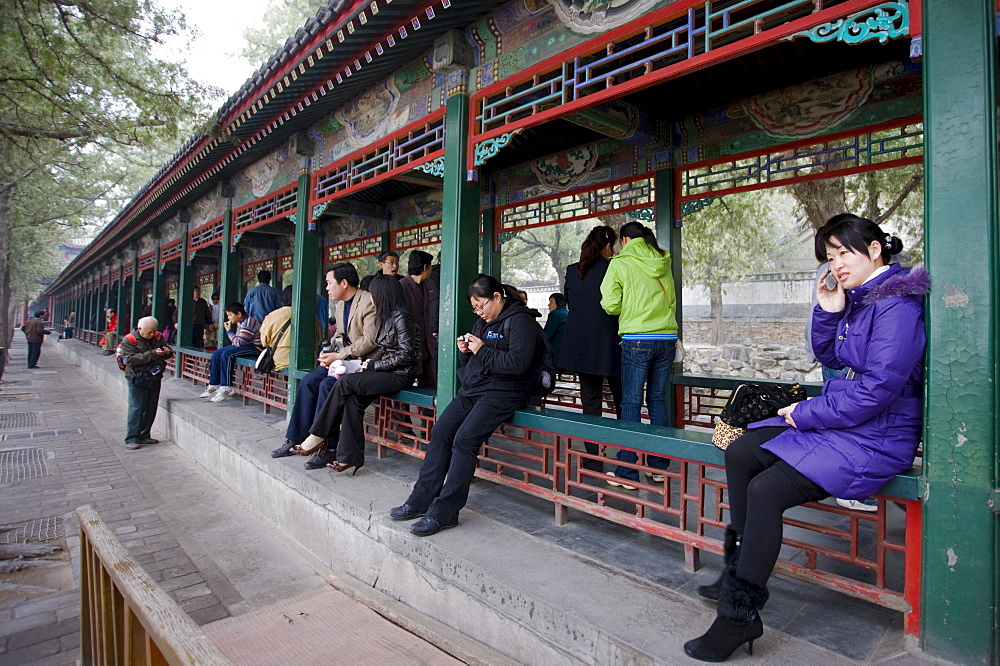 Visitors sit along the Long Corridor (Chang Lang) at The Summer Palace, Beijing, China