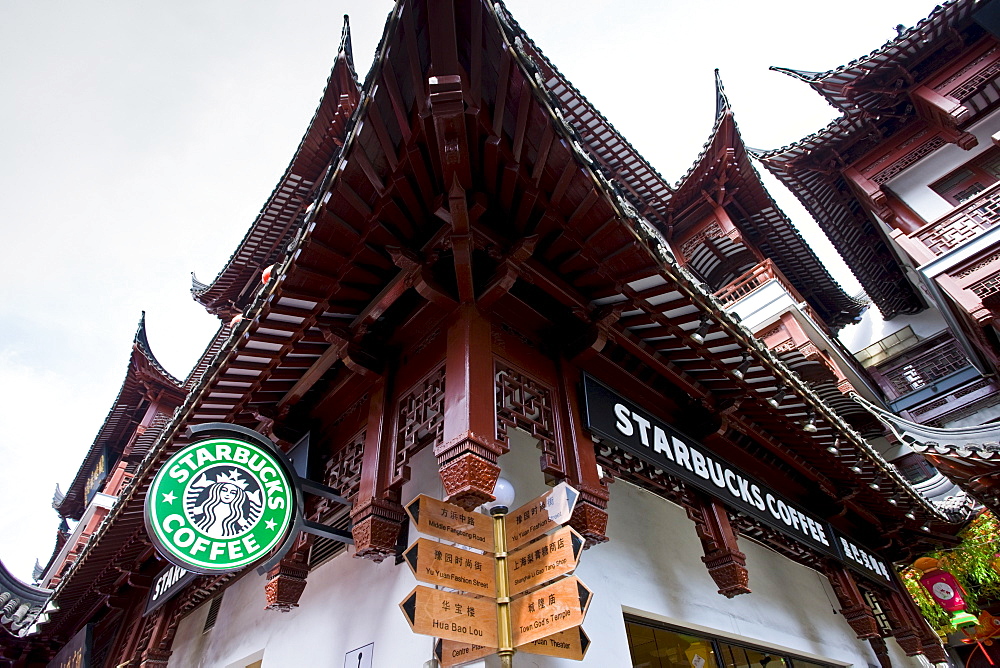 Starbucks coffee shop, American influence, alongside Chinese street signs in Yu Garden Bazaar Market, Shanghai, China