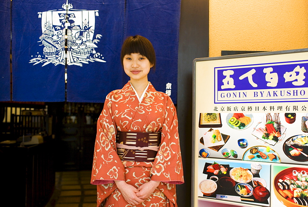 Hostess stands at the entrance of Gonin Byakusho Japanese Restaurant in the Beijing Hotel, China