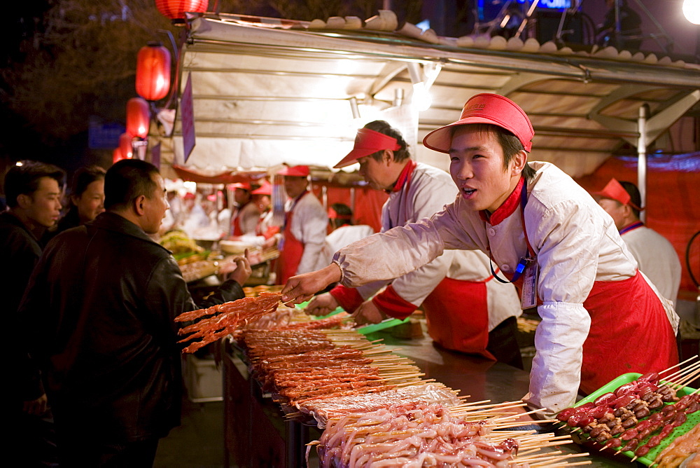 Stall selling meat kebabs in the Night Market, Wangfujing Street, Beijing, China