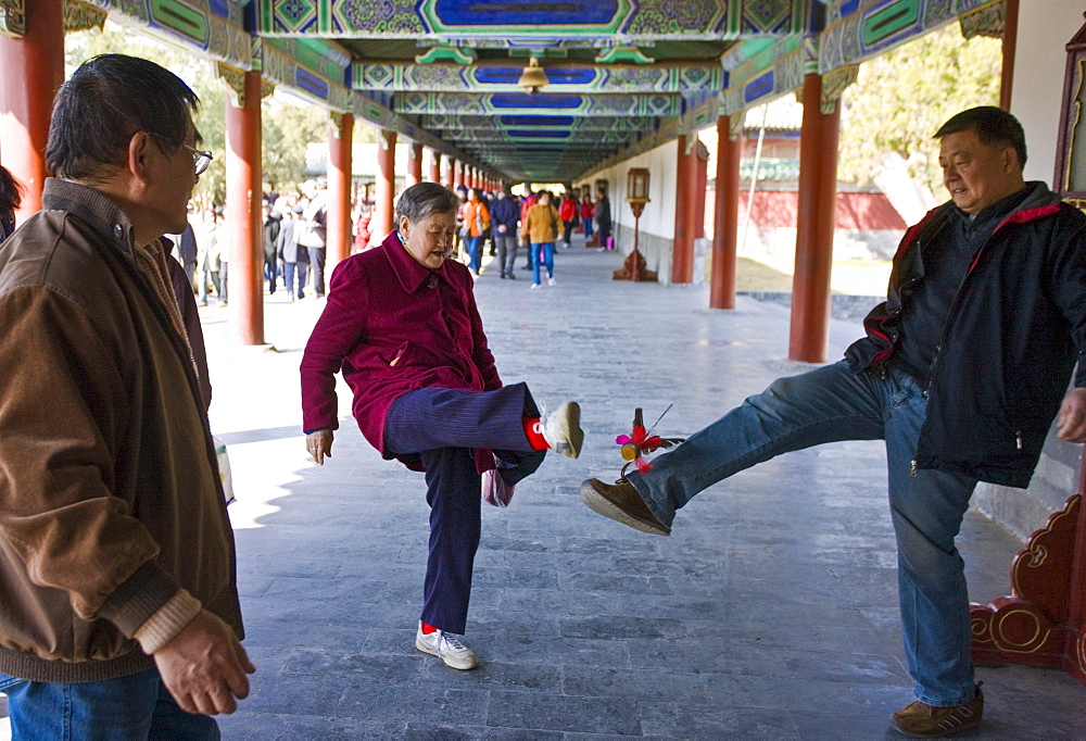 Pensioners play shuttlecock with their feet in the Ghost Corridor in park of the Temple of Heaven, Beijing, China