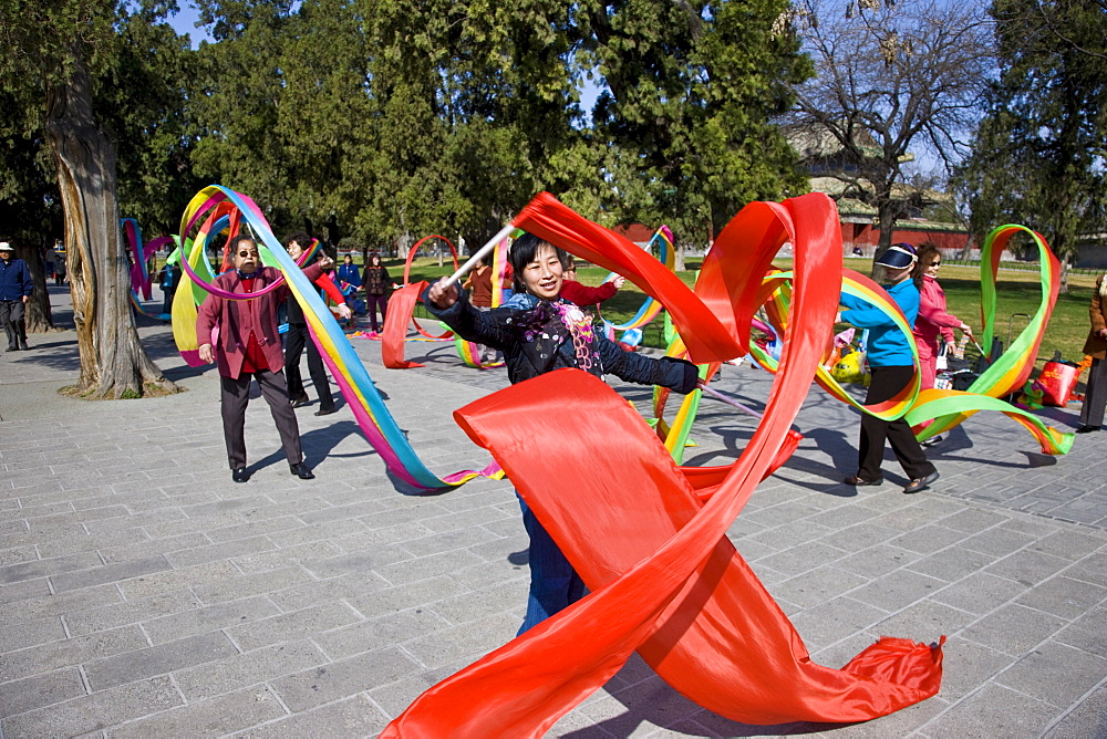 Women practise tai chi dancing with ribbons in park of the Temple of Heaven, Beijing, China