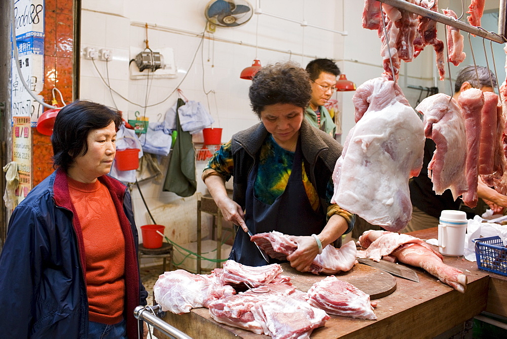 Fresh meat on sale in butcher shop in old Chinese Soho food market in Graham Street, Hong Kong, China