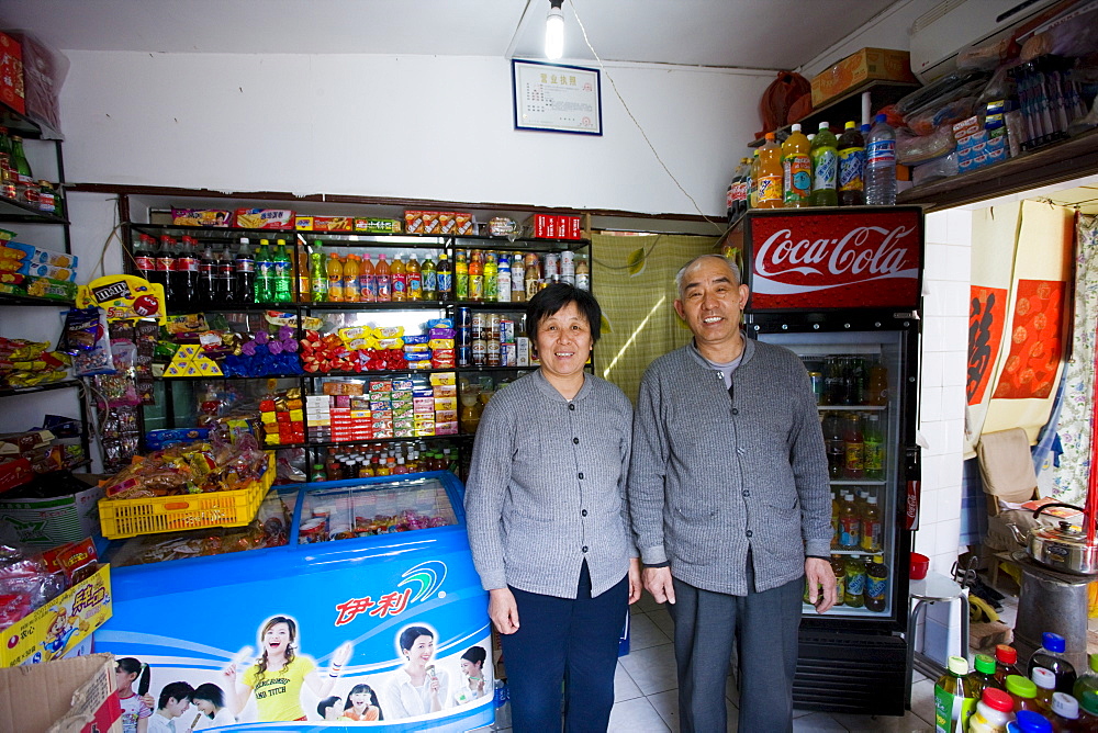 Shopkeepers in traditional shop for groceries, sweets and drinks, Hutongs Area, Beijing, China