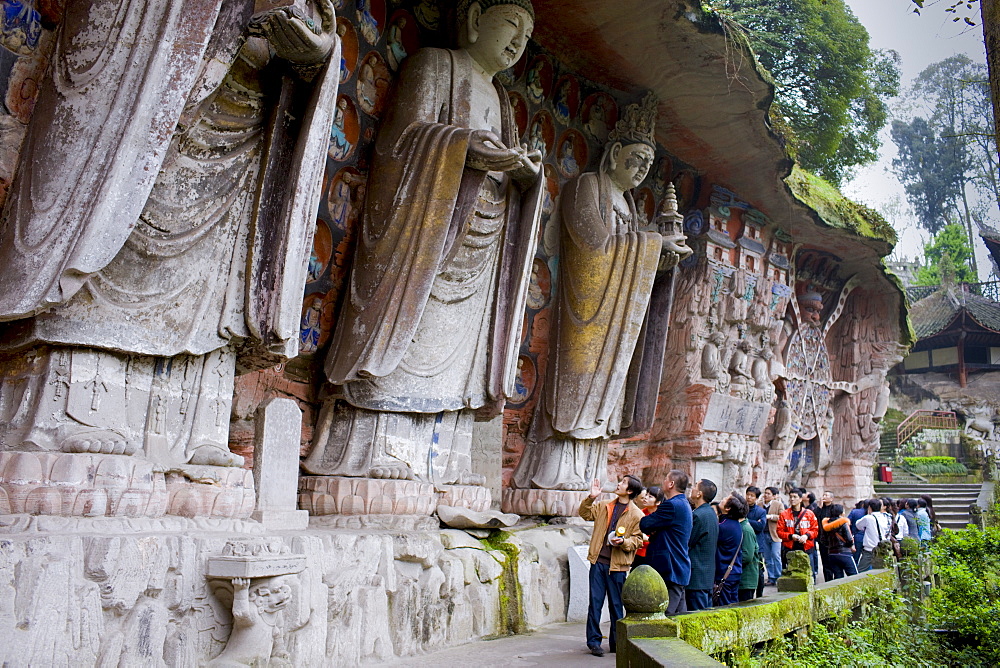 Tourists at Dazu rock carvings of Buddha of Great Sunlight, Buddha of Mercy at Mount Baoding, China