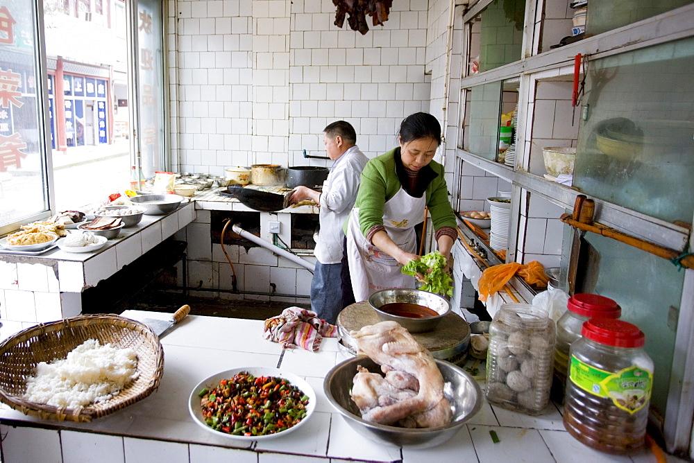 Chefs at work cooking in local street restaurant at Baoding in Dazu County, Chongqing, China