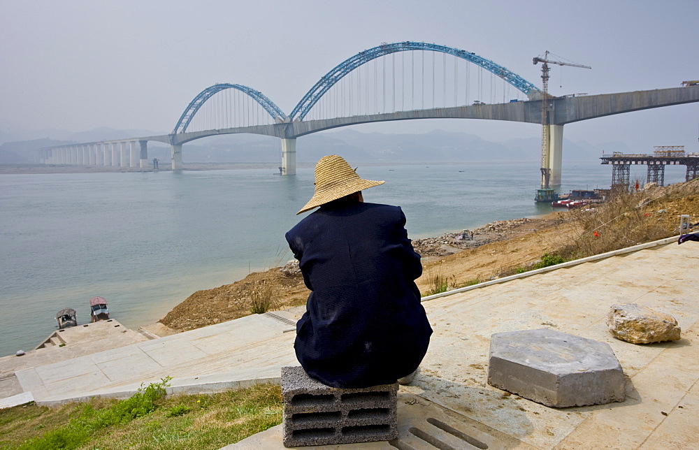 Man watches construction of a railway bridge in Yichang, China