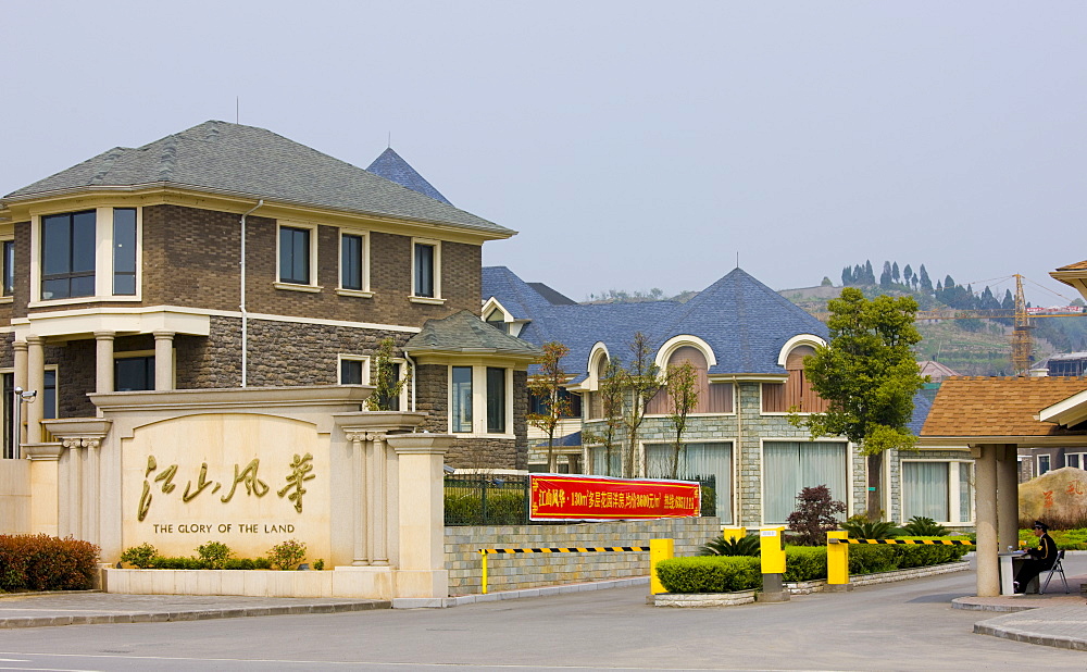 Western-style modern gated housing development with security guard and barriers, Yichang, China