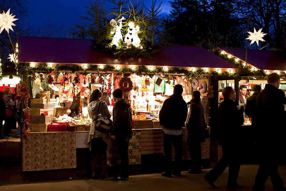 People shopping at traditional stall at Christmas market, Winter Wonderland, in Hyde Park, London