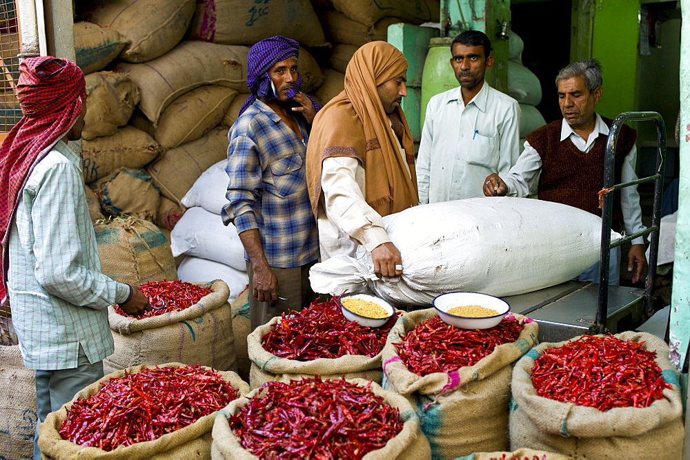 Businessmen and porters at stall selling red chillies at Khari Baoli spice and dried foods market, Old Delhi, India