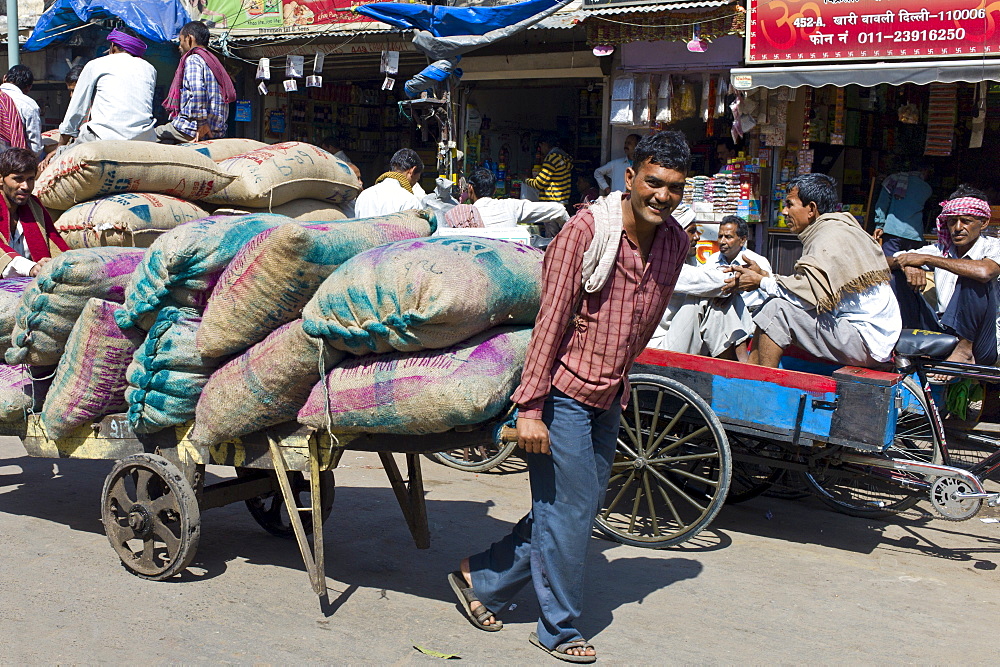 Porters with sacks of dates at Khari Baoli spice and dried foods market, Old Delhi, India