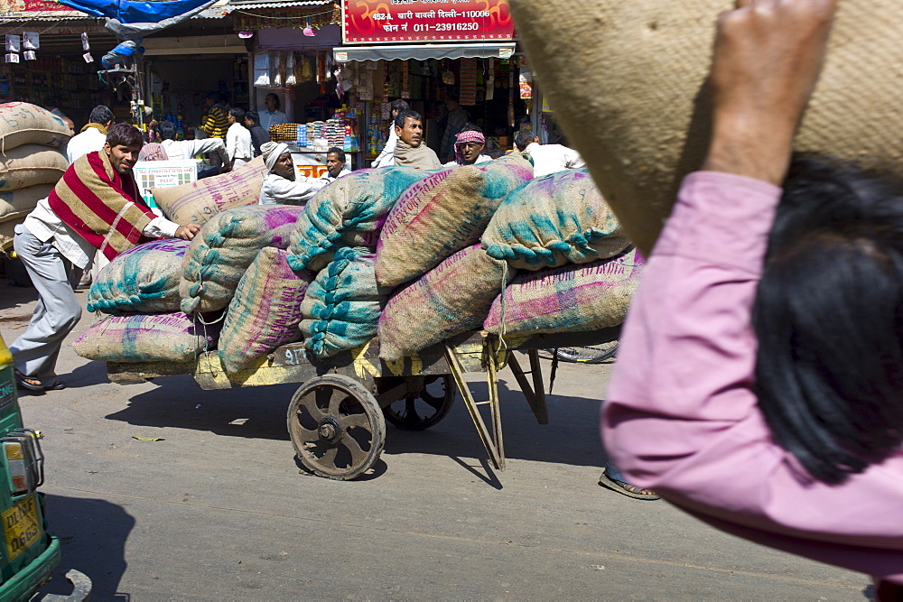 Porters with sacks of dates at Khari Baoli spice and dried foods market, Old Delhi, India