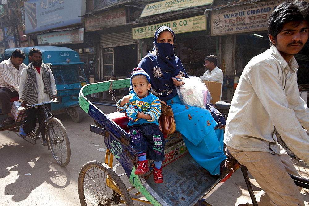 Muslim woman and child in rickshaw in Old Delhi, India