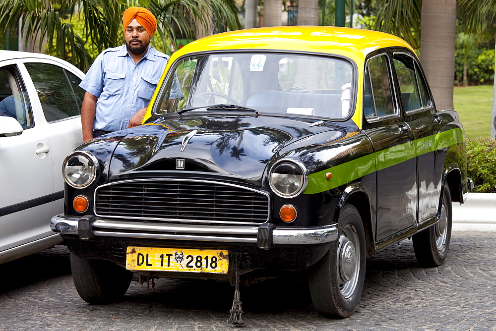 Sikh taxi driver with classic Ambassador taxi at The Imperial Hotel, New Delhi, India