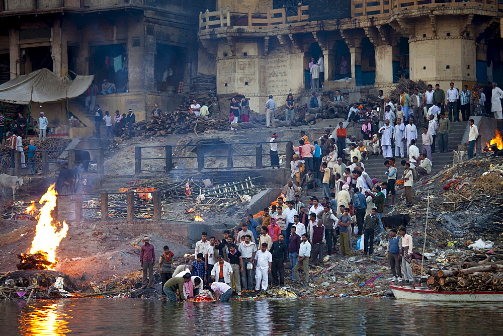 Body bathed in River Ganges and traditional Hindu cremation on funeral pyre at Manikarnika Ghat in Holy City of Varanasi, Benares, India