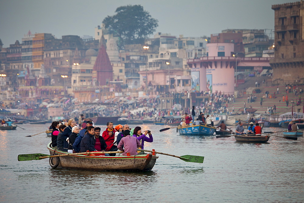 Traditional scenes of tourists in boats on River Ganges at Varanasi, Benares, Northern India