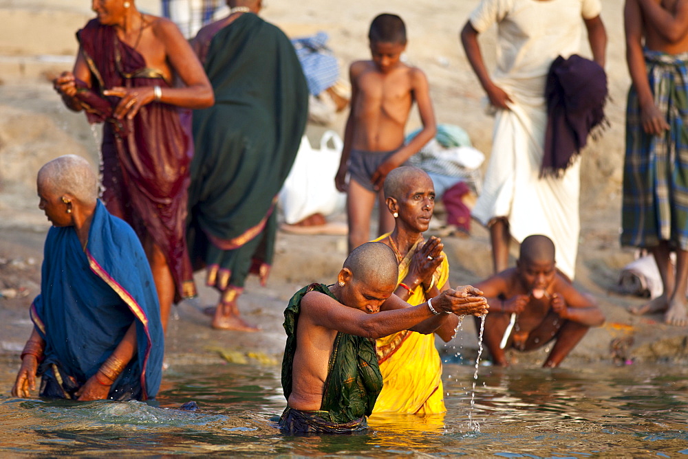 Indian Hindu pilgrims bathing in The Ganges River at Dashashwamedh Ghat in Holy City of Varanasi, Benares, India