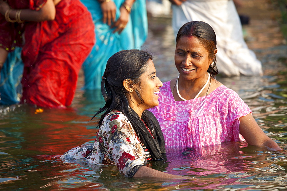 Indian Hindu pilgrims bathing in The Ganges River at Dashashwamedh Ghat in Holy City of Varanasi, Benares, India