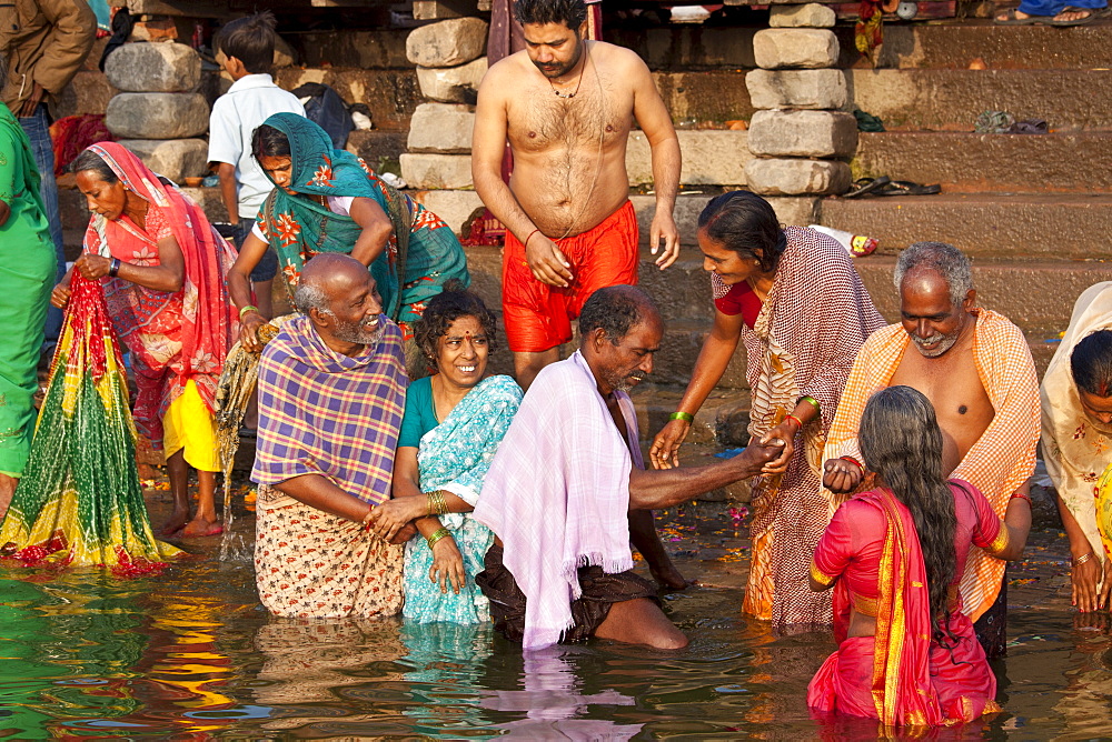 Indian Hindu pilgrims bathing in The Ganges River at Dashashwamedh Ghat in Holy City of Varanasi, Benares, India