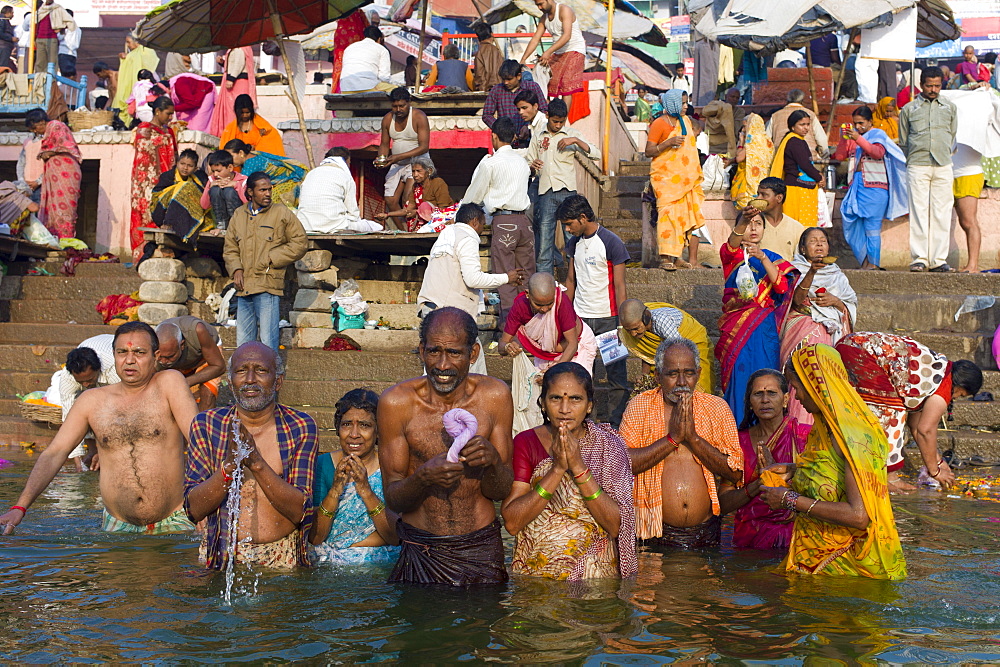 Indian Hindu pilgrims bathing in The Ganges River at Dashashwamedh Ghat in Holy City of Varanasi, Benares, India