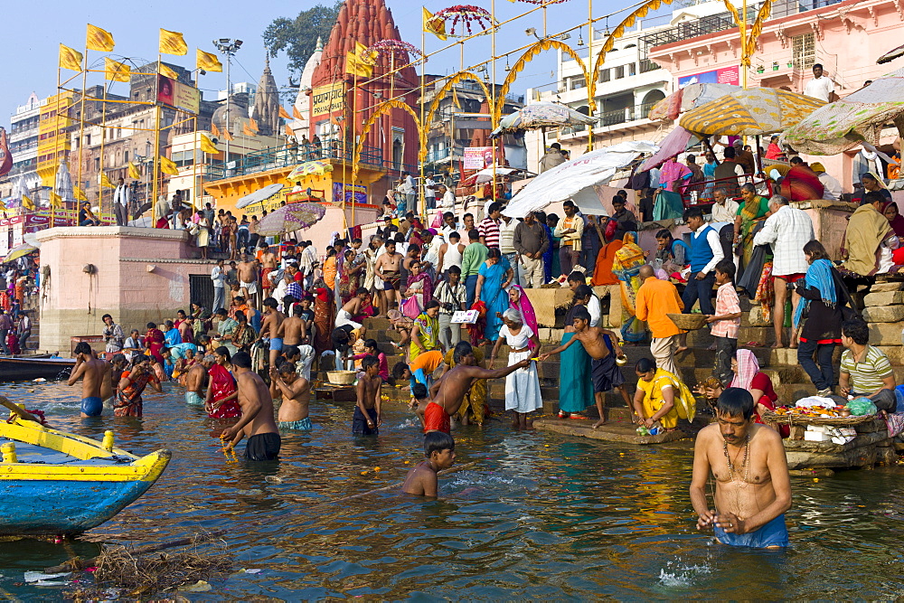 Indian Hindu pilgrims bathing in The Ganges River at Dashashwamedh Ghat in Holy City of Varanasi, Benares, India