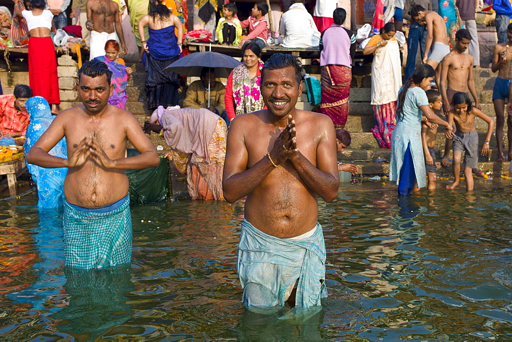 Indian Hindu pilgrims bathing in The Ganges River at Dashashwamedh Ghat in Holy City of Varanasi, Benares, India