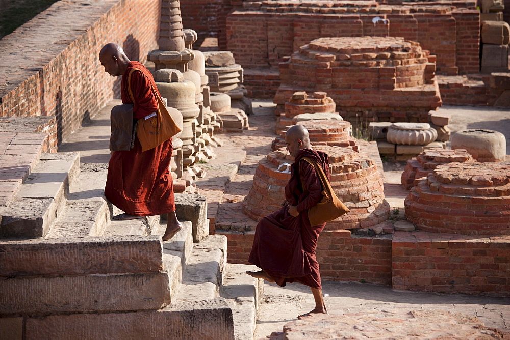 Buddhist monks visiting Dharmarajika Stupa at Sarnath ruins near Varanasi, Benares, Northern India