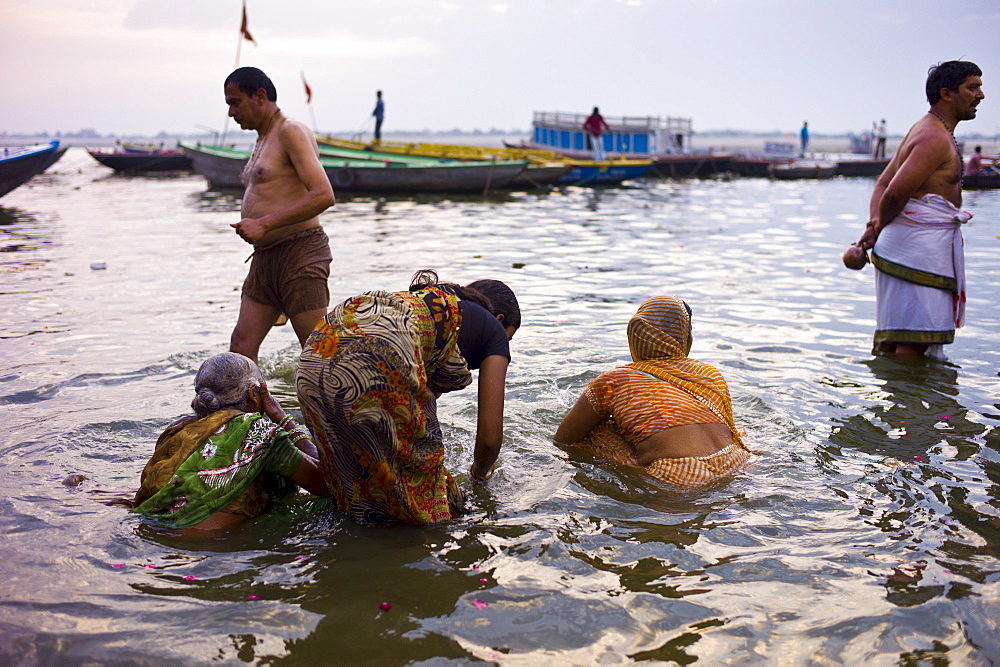 Indian Hindu pilgrims bathing in The Ganges River at Dashashwamedh Ghat in Holy City of Varanasi, Benares, India