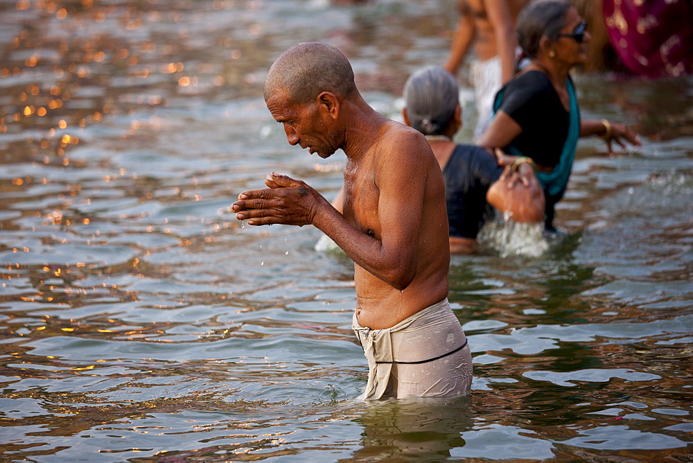 Indian Hindu pilgrim bathing and praying in The Ganges River at Dashashwamedh Ghat in Holy City of Varanasi, India