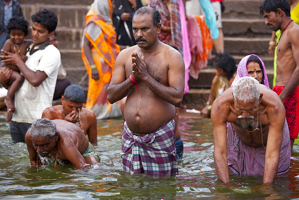 Indian Hindu pilgrims bathing in The Ganges River at Dashashwamedh Ghat in Holy City of Varanasi, Benares, India