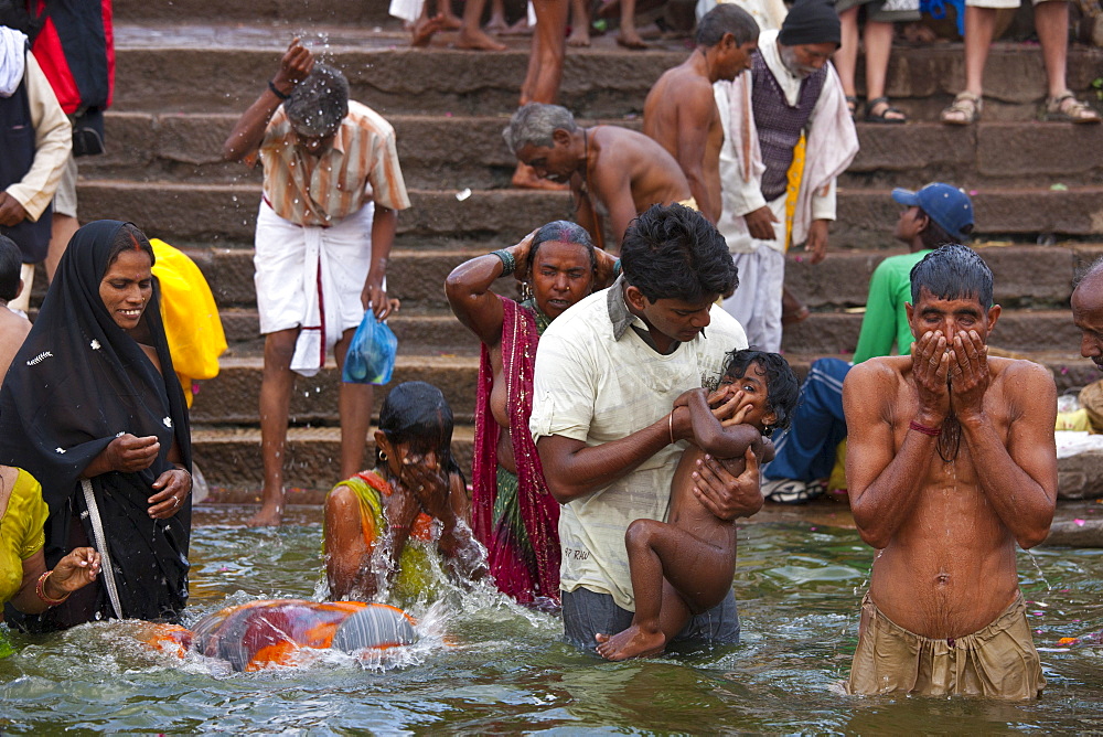 Indian Hindu pilgrims bathing in The Ganges River at Dashashwamedh Ghat in Holy City of Varanasi, Benares, India