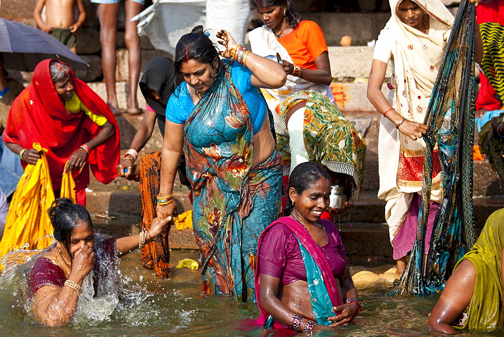 Indian Hindu pilgrims bathing in The Ganges River at Dashashwamedh Ghat in Holy City of Varanasi, Benares, India