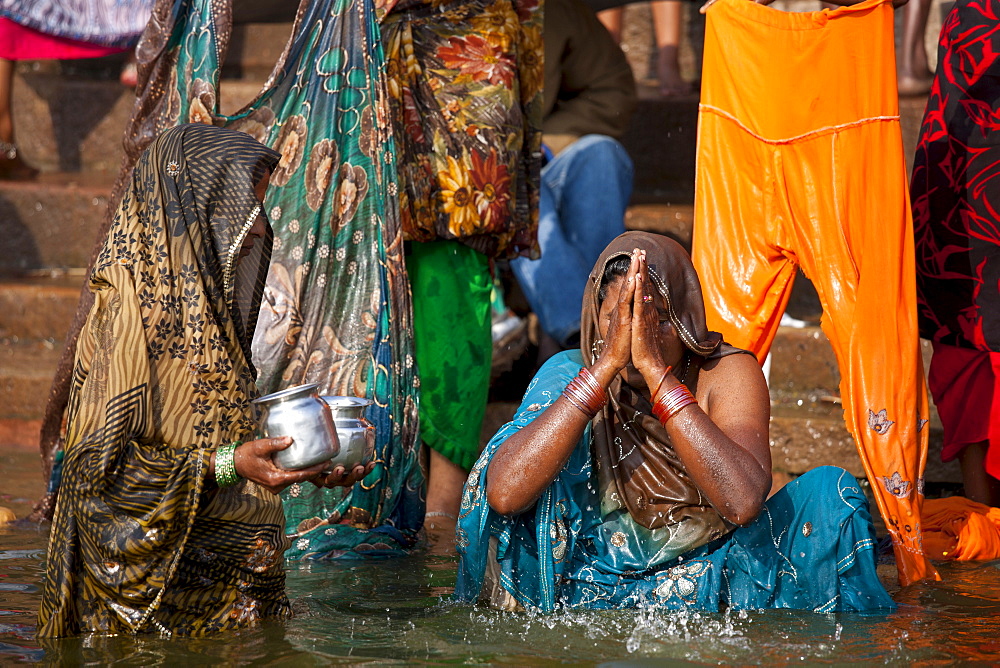 Indian Hindu pilgrims bathing in The Ganges River at Dashashwamedh Ghat in Holy City of Varanasi, Benares, India