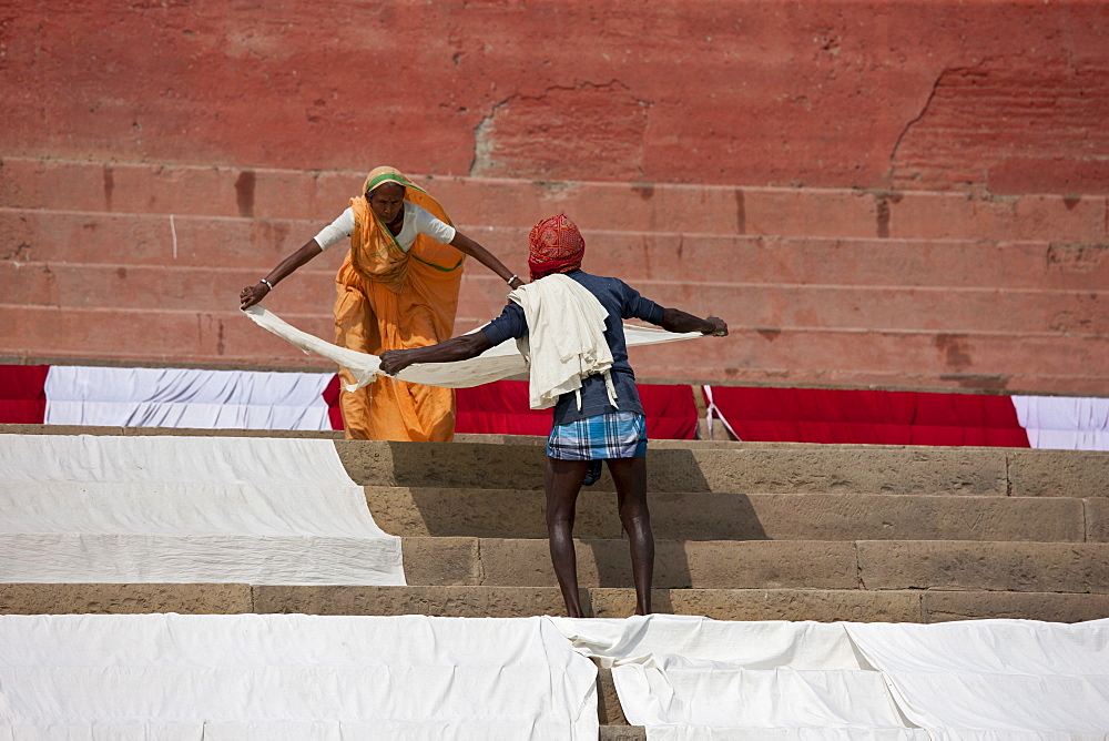 Indians doing laundry using the waters of the The Ganges River and the steps Kali Ghat in City of Varanasi, Benares, India