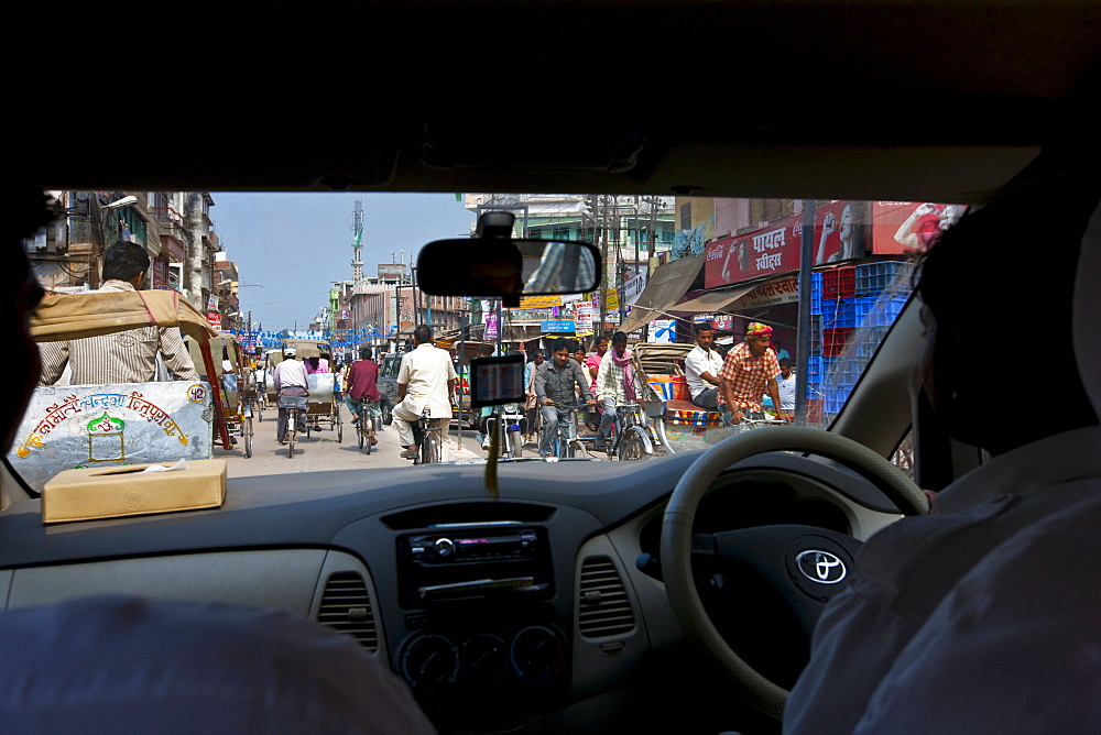 Busy street scene viewed through taxi windscreen in city of Varanasi, Benares, Northern India