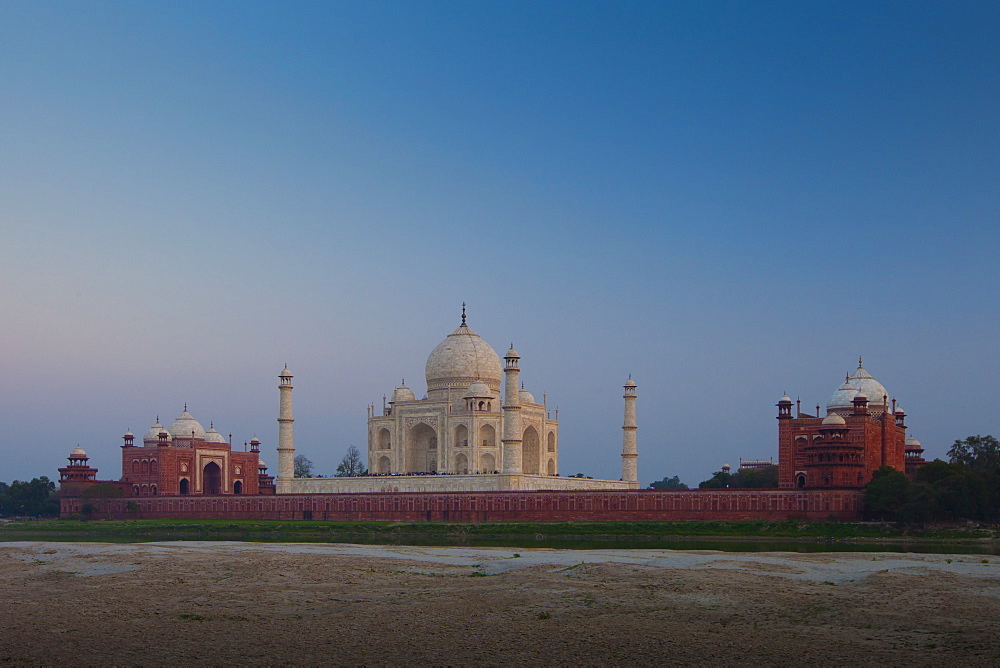 The Taj Mahal and Mosque North Side viewed across Yamuna River at sunset , India